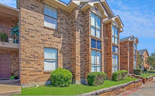 Brick building with tall windows and landscaping