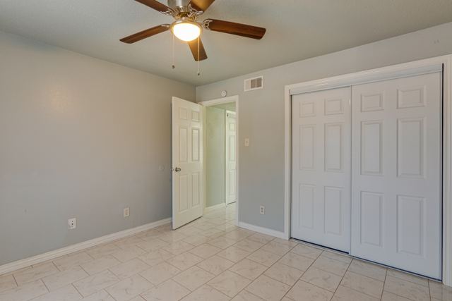 Bedroom with ceiling fan and double closet doors