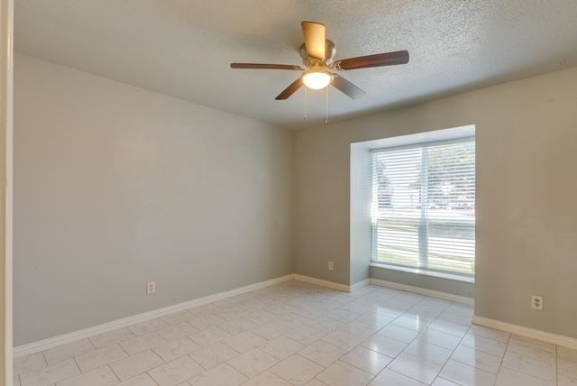 Bedroom with large window and ceiling fan